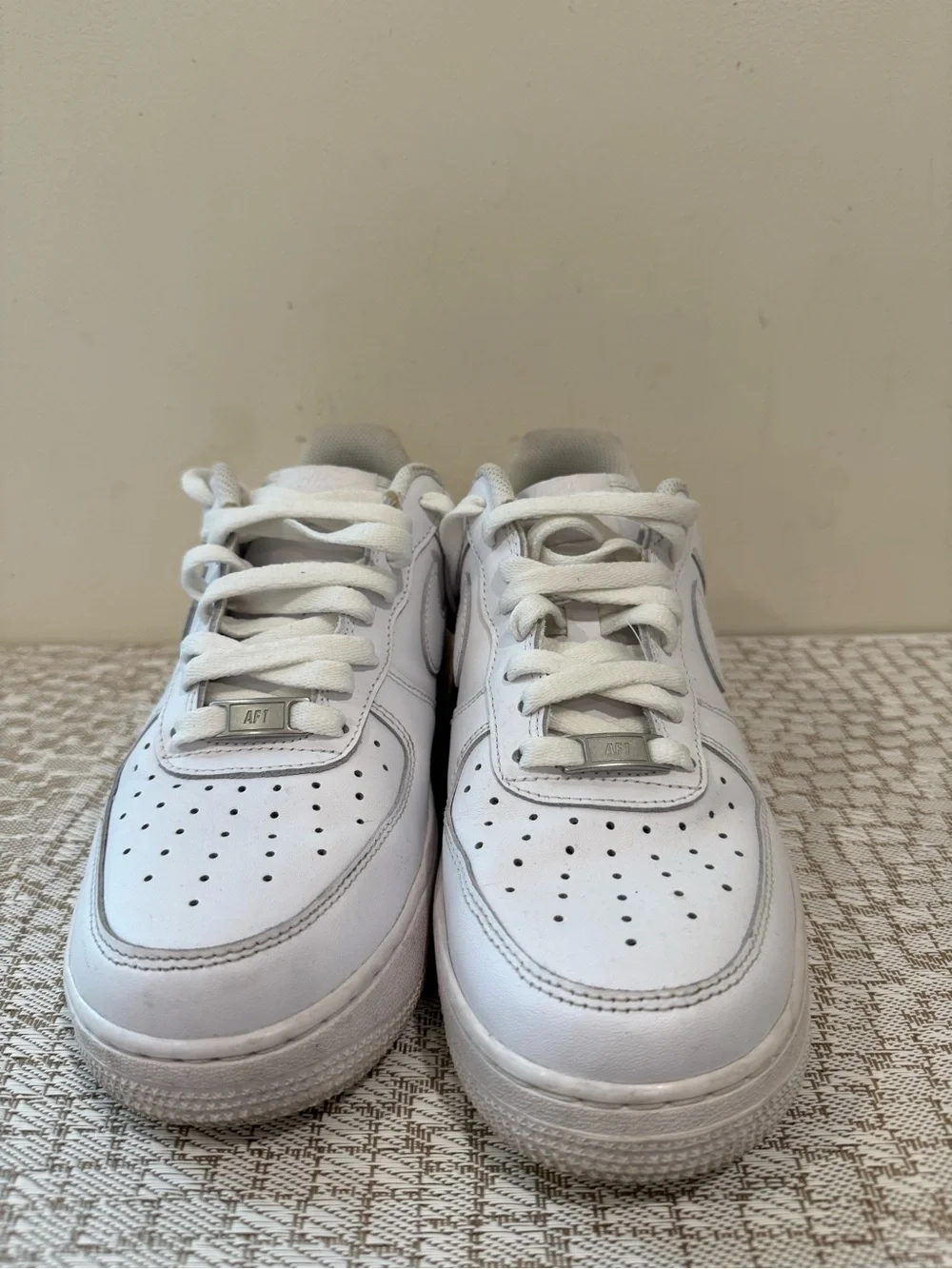 These are iconic Nike Air Force 1 sneakers in an all-white colorway.